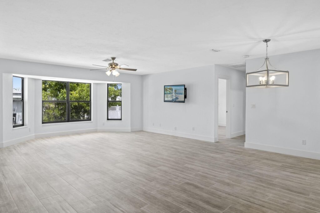 empty Florida living room with clean interiors and visible air-conditioning vents.