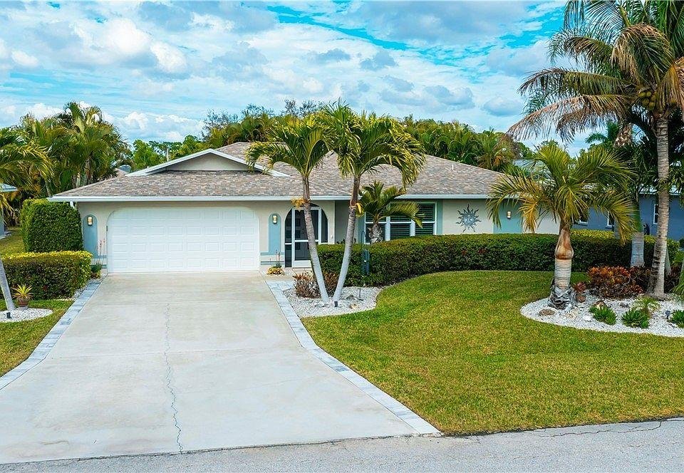 an exterior photo of a Florida home with a trimmed lawn, healthy landscaping, and a clear driveway.
